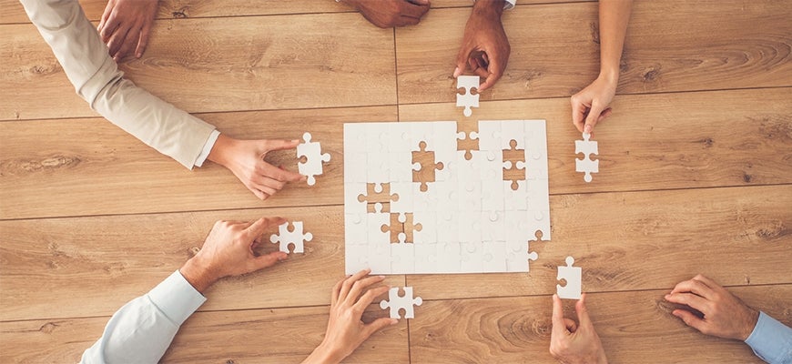 workers' hands assembling a jigsaw