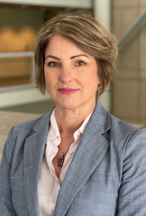 Woman with short brown hair wearing grey jacket