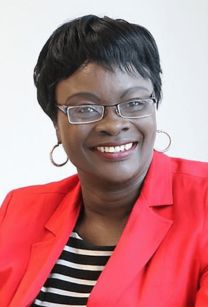 Headshot of woman with short dark hair wearing glasses and a red jacket