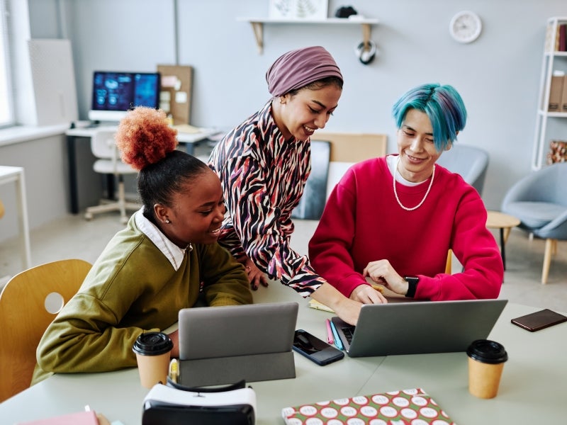 Three people at a computer